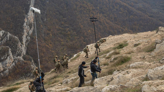 Crew and actors on a steep mountain slope