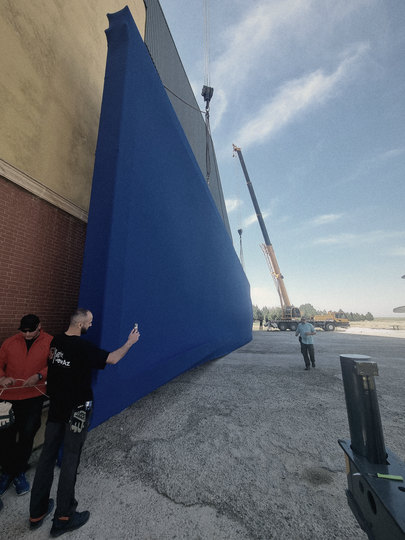 The blue-screen wall next to the crew