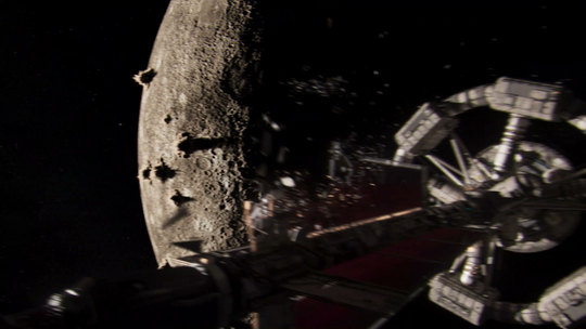 The ship passing a cratered moon